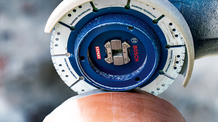 A diamond cutting blade trims a ceramic pipe with precision.