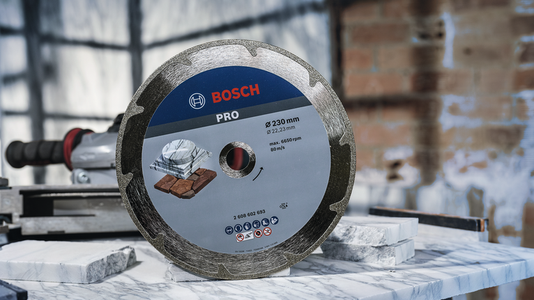 Diamond saw blade displayed upright on a marble slab in a workshop setting.