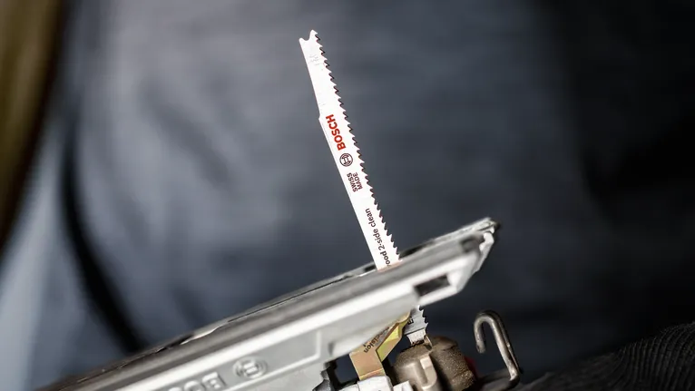 Close-up of a jigsaw blade attached to a power tool.