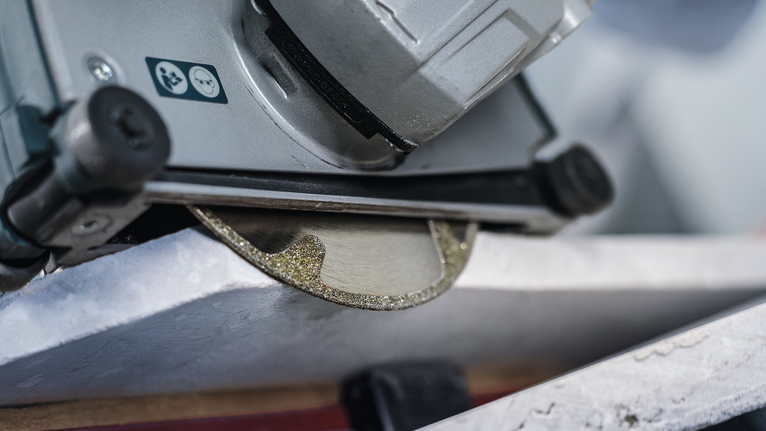 Diamond saw blade cuts through a piece of stone.