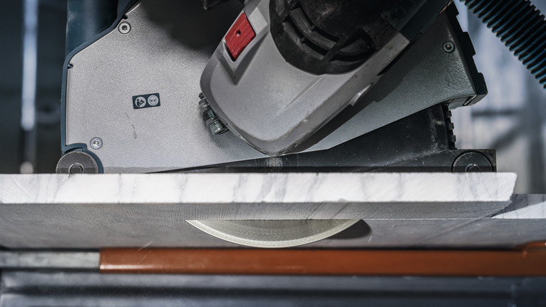 Circular saw cutting through a slab of marble.