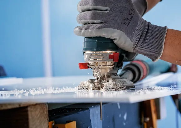 Bosch jigsaw blade cutting through acrylic sheet.