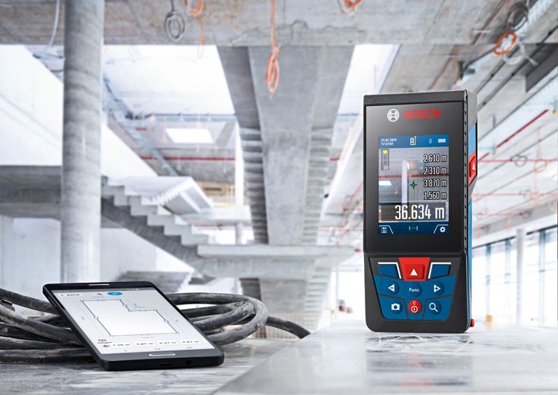 Medição a laser e tablet em superfície de betão num estaleiro de obras.