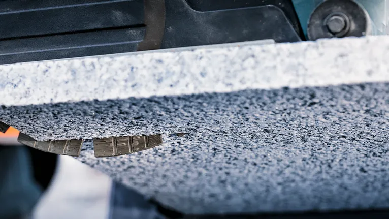 Broca diamantada fazendo um furo preciso numa placa de pedra grossa.