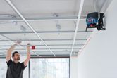 Una persona alinea la estructura del techo utilizando una herramienta de nivelación láser.