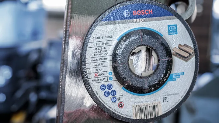 Disco de corte de metal montado en una amoladora en un taller.