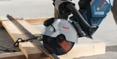 Una persona que usa equipo de seguridad corta varillas de metal con una amoladora inalámbrica.