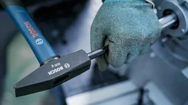 Una persona que lleva equipo de seguridad aprieta un perno con un martillo.