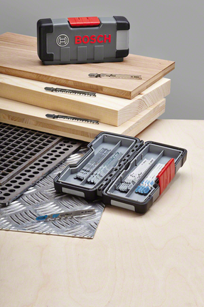 Ein Satz Stichsägeblätter, ausgestellt auf Holz- und Metallplatten, die Blätter sind in einem Koffer ordentlich verstaut.