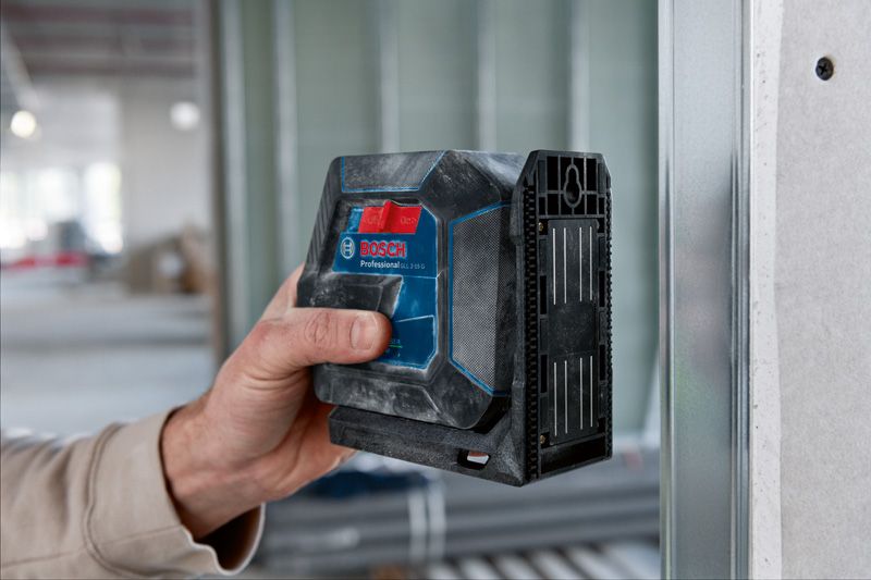 Eine Person verwendet ein Lasernivellierungswerkzeug an einem Metallwandrahmen im Innenbereich.