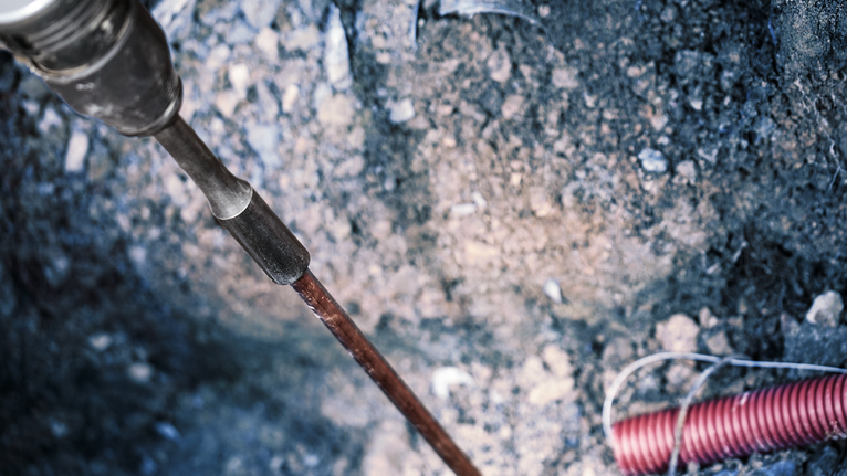 Abbruchhammer durchbricht den Boden auf einer Baustelle.