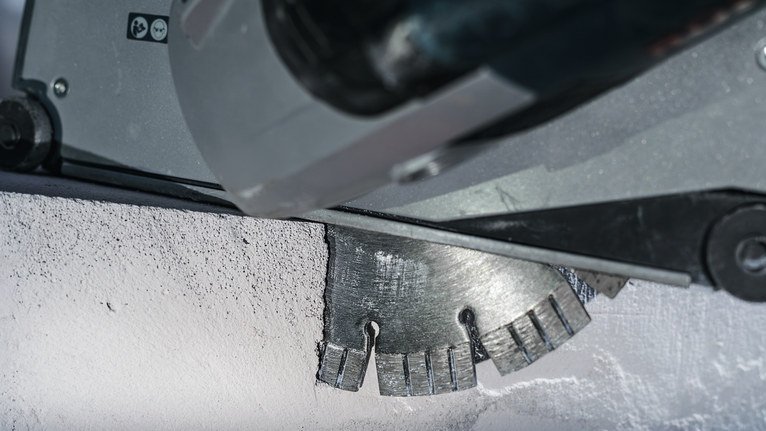Schneidklinge, die eine Nut in eine Betonwand schneidet.