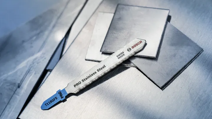 Stichsägeblatt für Edelstahl, das auf flache Metallbleche gelegt wird.