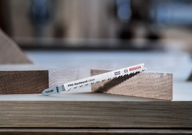 Sägeblatt zum Schneiden von Hartholz, das zwischen zwei Holzstücken platziert wird.