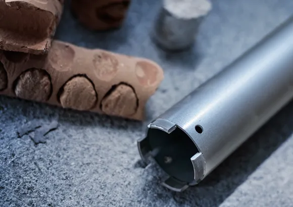 Kernbohrer auf Beton mit gebohrtem Ziegel und zylindrischer Kernprobe.