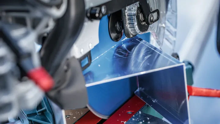 Eine Kreissäge schneidet durch ein Metallblech auf einer Werkbank.