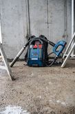 Ein kabelloser Rucksackstaubsauger steht auf dem Boden einer Baustelle.