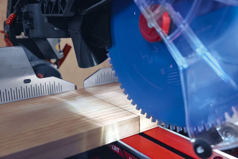 Ein Gehrungssägeblatt schneidet ein Holzbrett in einem markierten Winkel.