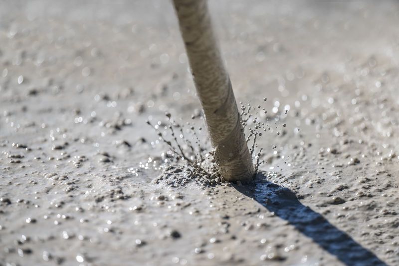 Der Bohrer gräbt sich durch den nassen Beton, Wasser und Schutt spritzen um ihn herum.