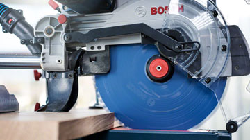 Eine Bosch Professional Kreissäge mit blauer Sägeblatt auf einem Holzarbeitsstück.