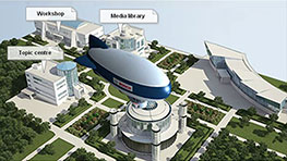 Ein blauer Zeppelin schwebt über einem modernen Campus mit verschiedenen Gebäuden.