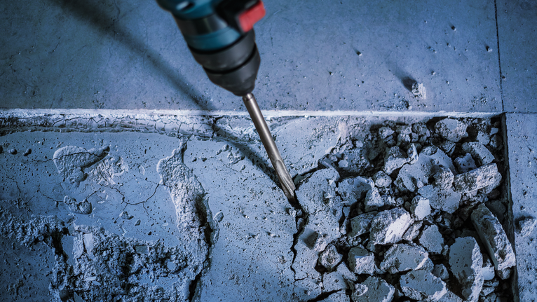 Marteau perforateur cassant des carreaux de sol en béton.