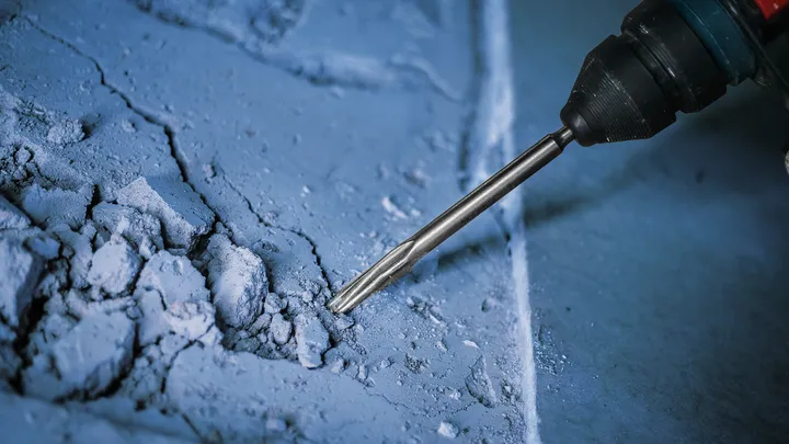 Marteau perforateur brisant une surface en béton.