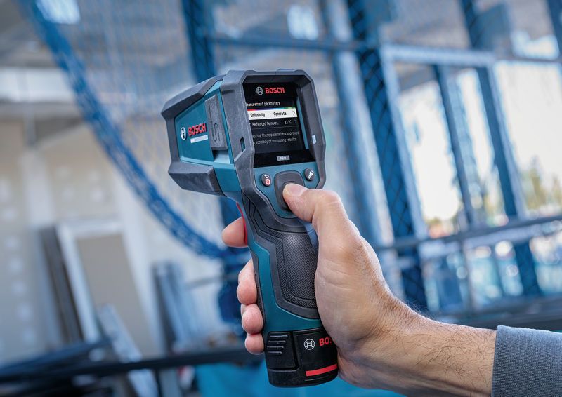 Personne utilisant un détecteur thermique portatif pour mesurer la température de surface à l'intérieur.