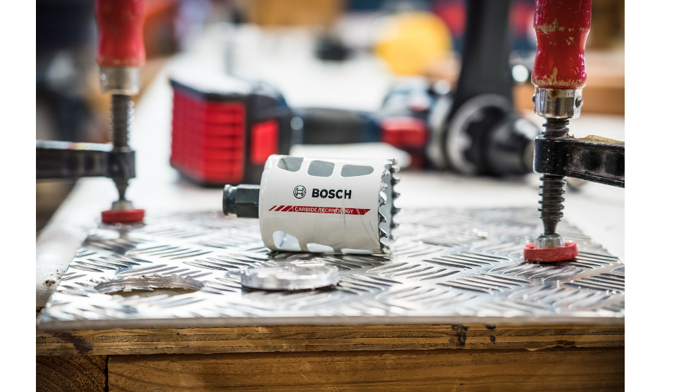 Un foret Bosch Professional sur une surface métallique avec des outils en arrière-plan.