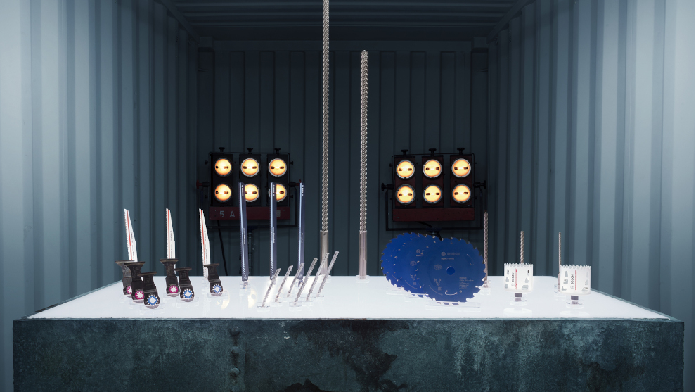 Outils Bosch Professional sur une table blanche dans un conteneur, éclairage industriel.