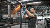 Man slijpt metalen frame.