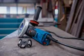 Haakse slijper met X-LOCK-systeem staat op een werkbank in een werkplaats.