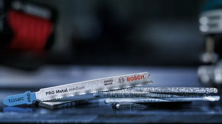 Metalen decoupeerzaagbladen rusten op een werkbank.