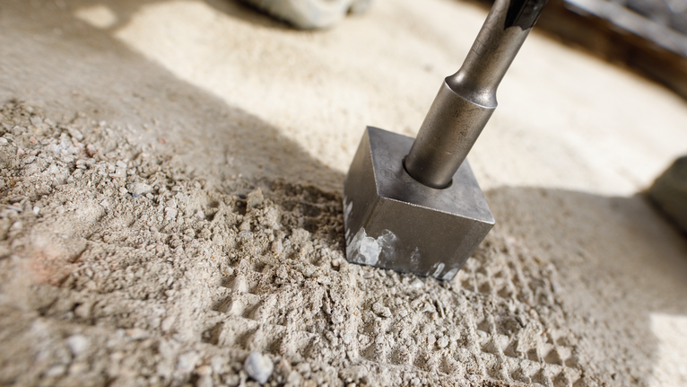 Beitelgereedschap dat betonoppervlak breekt.