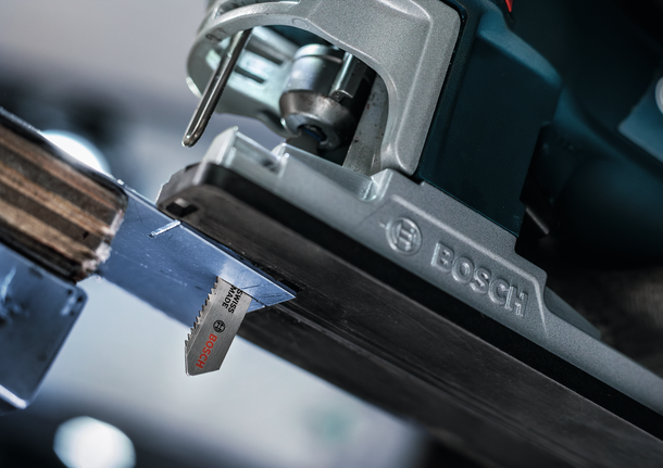 De decoupeerzaag zaagt door een metalen plaat, van dichtbij bekeken.