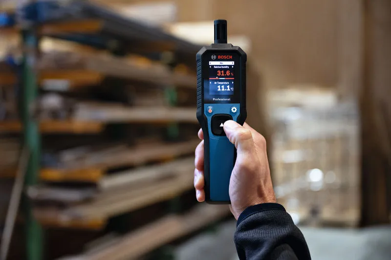 Een persoon houdt een thermo-hygrometer vast in een magazijn.