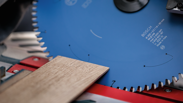Cirkelzaag met een blauw zaagblad, geschikt om een houten plank door te zagen.