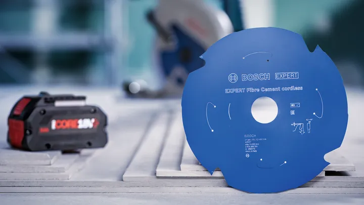 Cirkelzaagblad op een werkbank naast een accu voor elektrisch gereedschap.