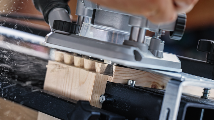 Persoon die een elektrisch gereedschap gebruikt om houtsnijwerk te maken.