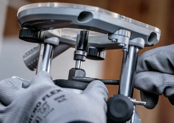 Een persoon die veiligheidsuitrusting draagt, stelt een elektrisch gereedschap af met een sleutel.