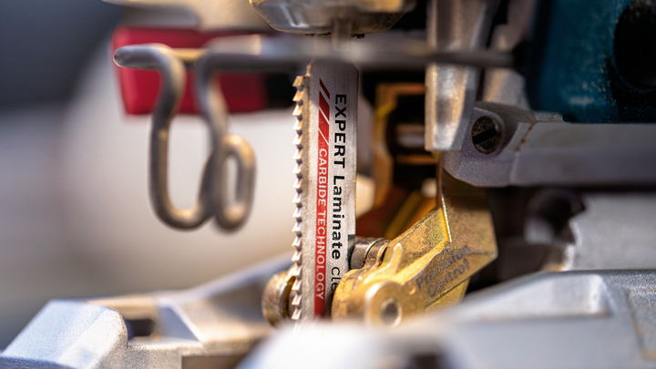 Close-up van een decoupeerzaagblad met hardmetalen tanden gemonteerd in een elektrisch gereedschap.