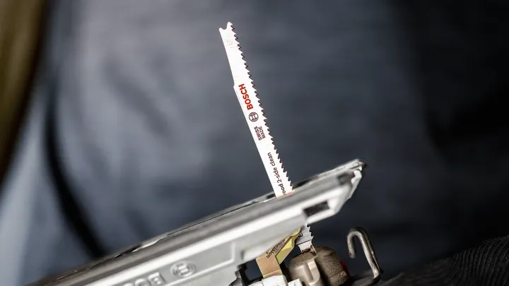 Close-up van een decoupeerzaagblad bevestigd aan een elektrisch gereedschap.