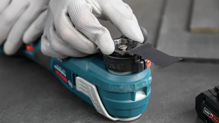 Een persoon die veiligheidsuitrusting draagt, stelt het mes van een multitool af.