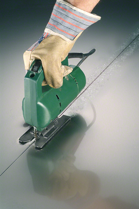 Лице, носещо предпазни средства, използва прободен трион, за да реже метал по права линия.