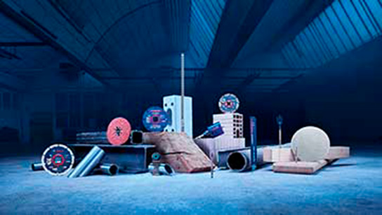 Várias ferramentas Bosch Professional exibidas em um ambiente de armazém com pouca luz.