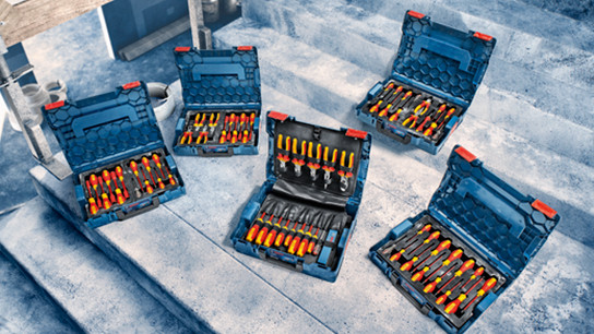 Cinco caixas de ferramentas Bosch Professional abertas com ferramentas laranjas e amarelas dispostas em degraus de concreto.