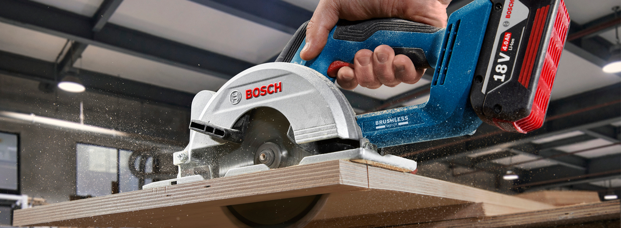 Uma serra circular profissional Bosch corta tábuas de madeira em uma oficina.