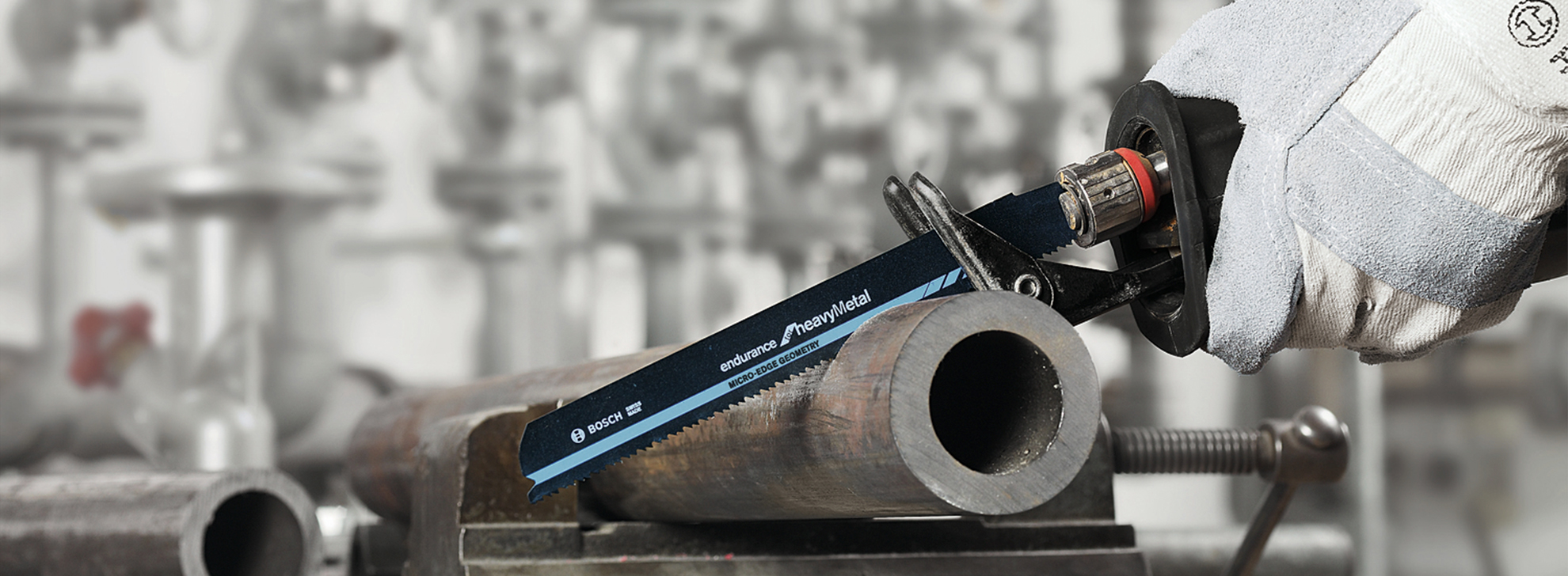 Uma serra de metal Bosch Professional está cortando um tubo de metal em uma oficina.