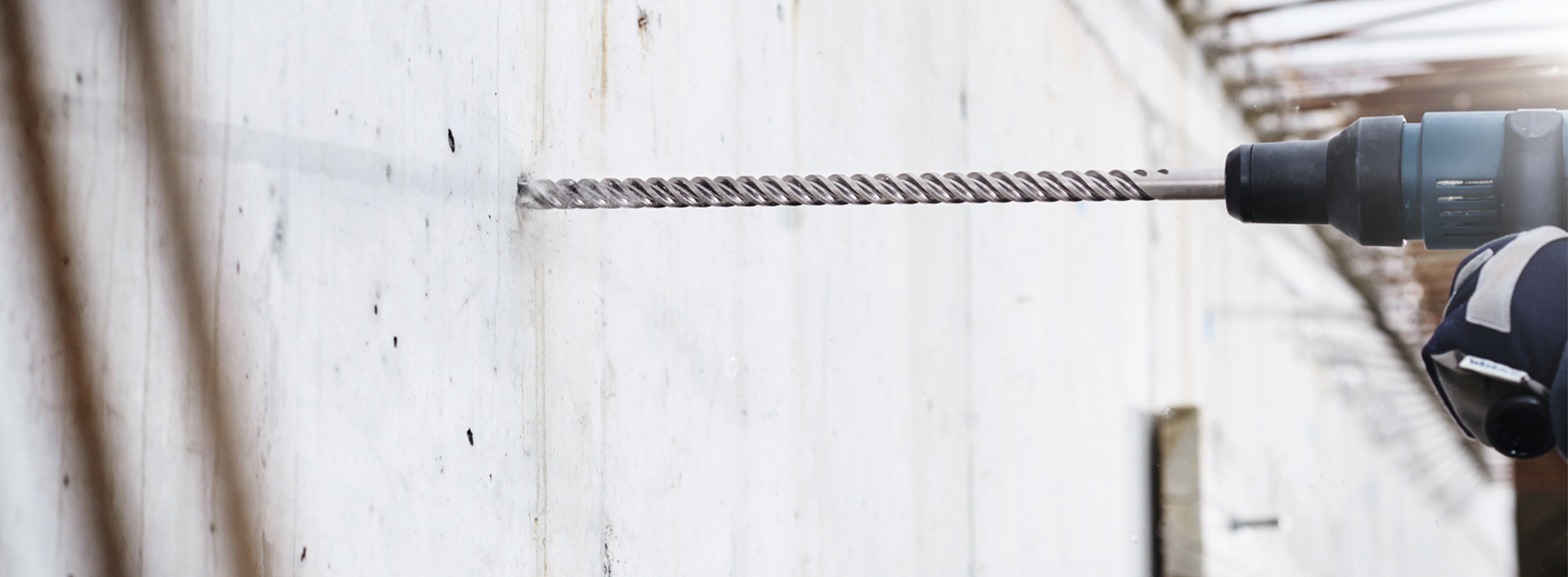 Uma furadeira Bosch Professional está perfurando uma parede branca, mostrando movimento.