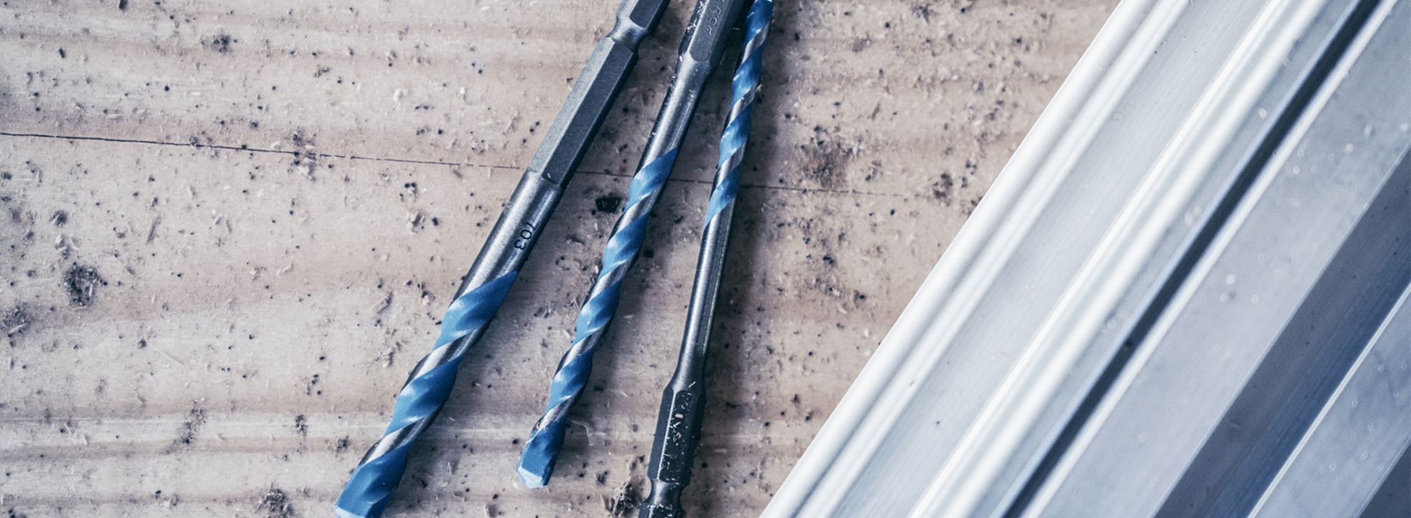 Brocas Bosch Professional em azul e prata sobre uma superfície texturizada.